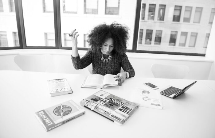 grayscale photography of woman reading book