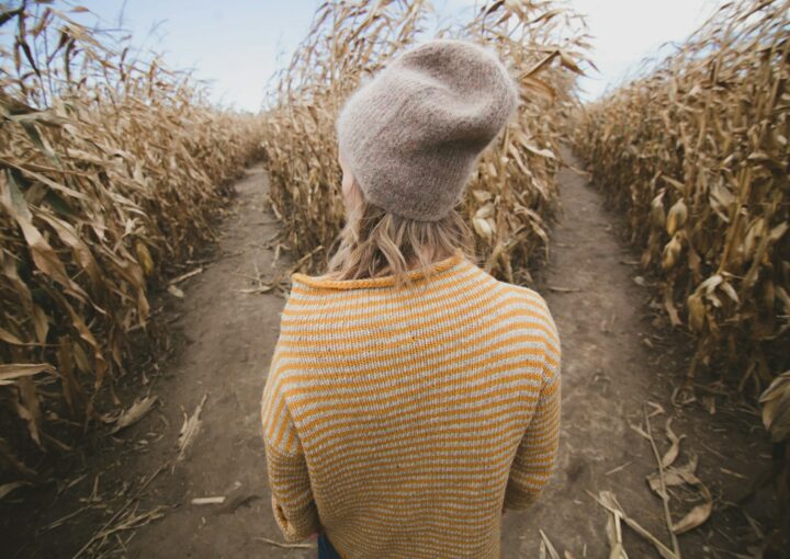 woman standing in brown field while looking sideways