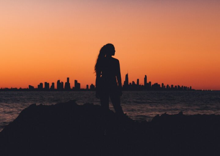 silhouette of woman near shoreline