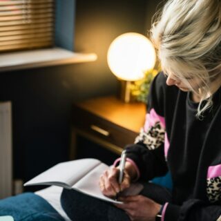 woman in black and white long sleeve shirt sitting on bed