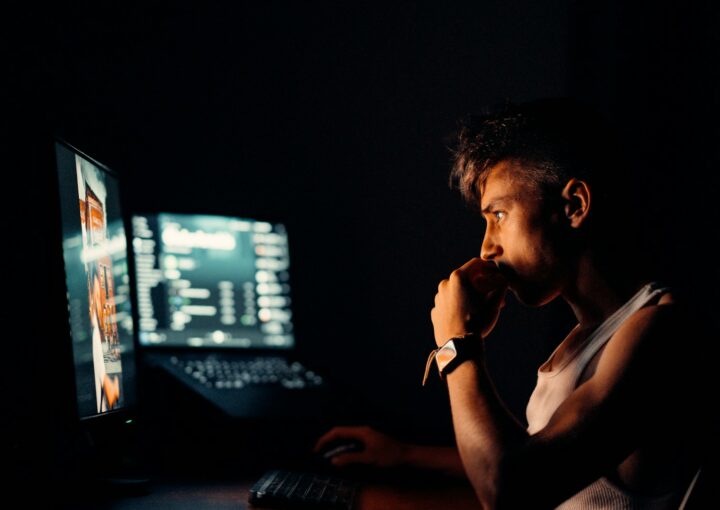 woman in black tank top sitting in front of computer