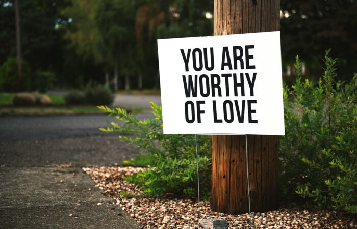 you are worthy of love sign beside tree and road