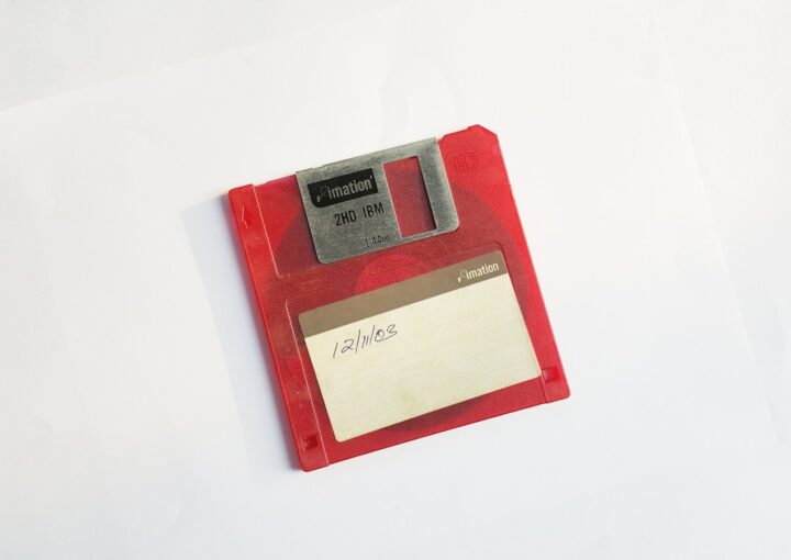 red and white floppy disk on white surface