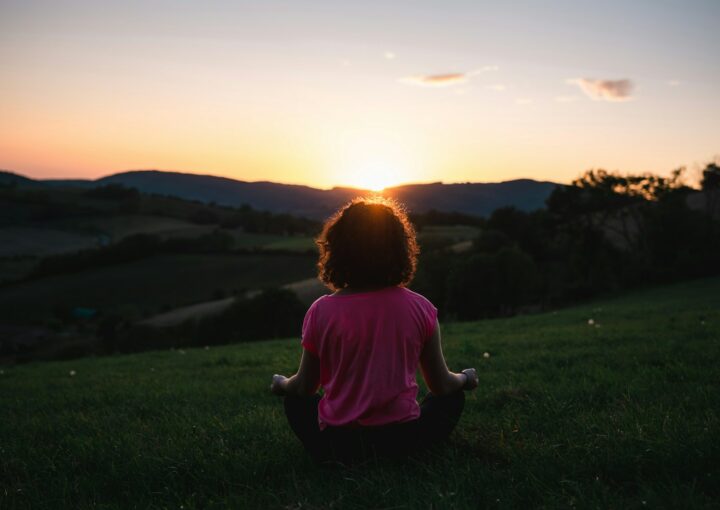 woman squatting in grass during golden hour