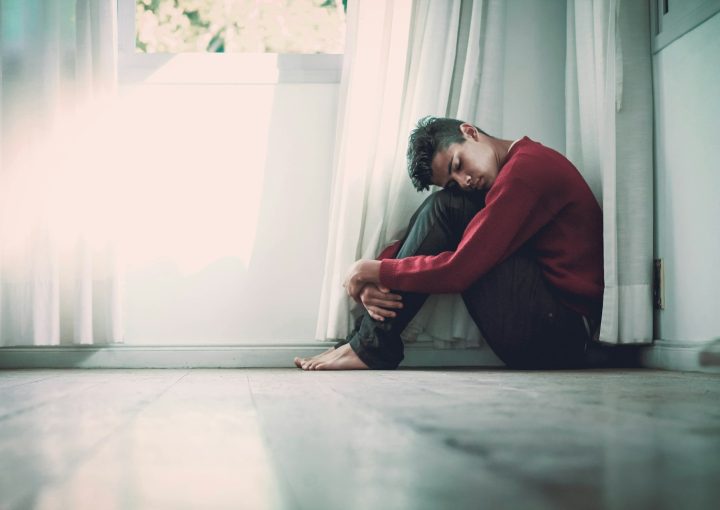 man beside white frame window