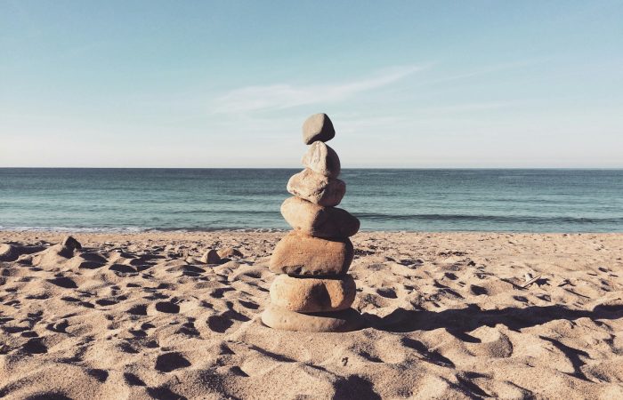 stacked stones on the sea shore during daytime