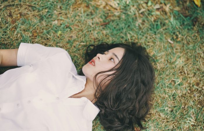 woman lying on green grass