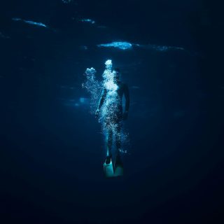 person diving on body of water