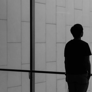 silhouette of a person facing glass wall