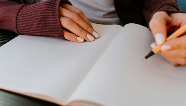 person writing on white paper