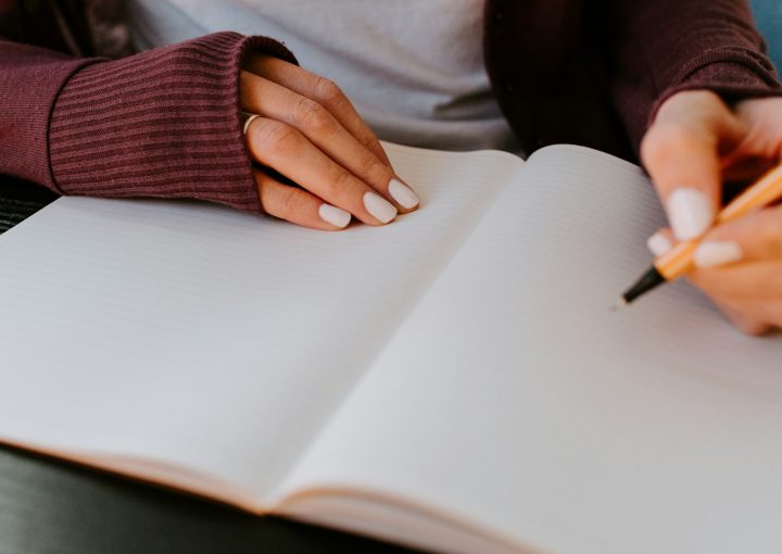 person writing on white paper