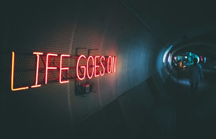 a neon sign that reads life goes on
