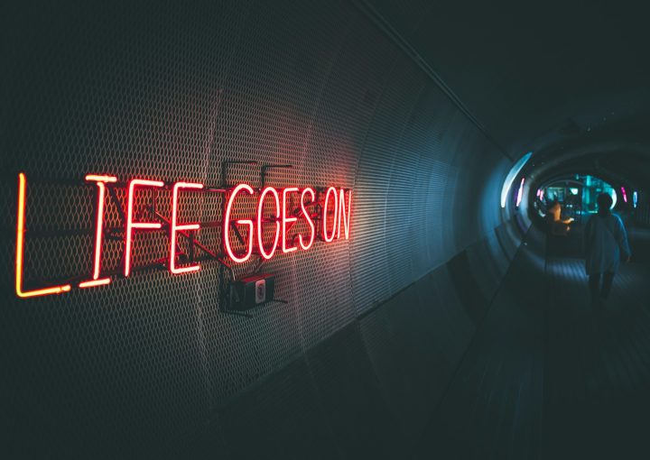 a neon sign that reads life goes on