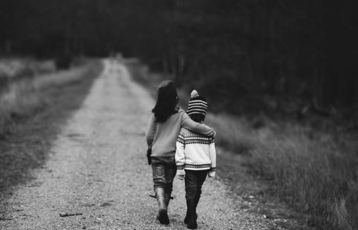grayscale photography of kids walking on road