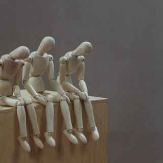 a group of wooden mannequins sitting on top of a wooden block