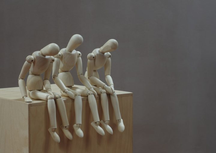 a group of wooden mannequins sitting on top of a wooden block