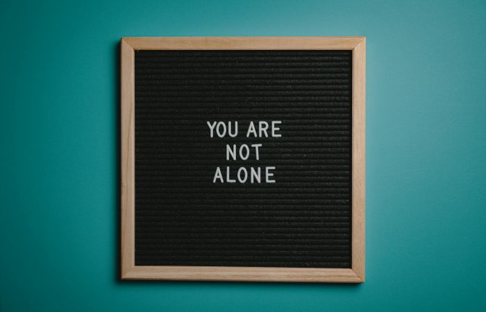 A wooden letter board displays a motivational message against a teal background.
