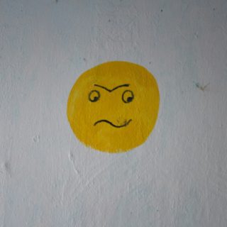 a yellow smiley face painted on a white wall