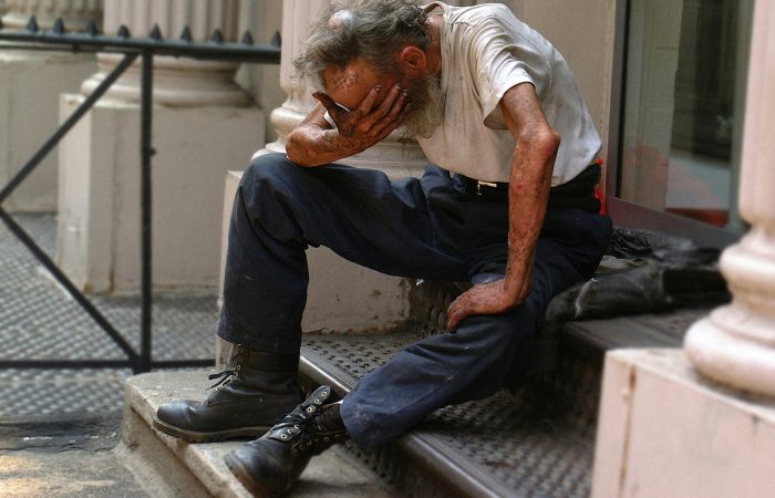 a man sitting on a step with his head in his hands