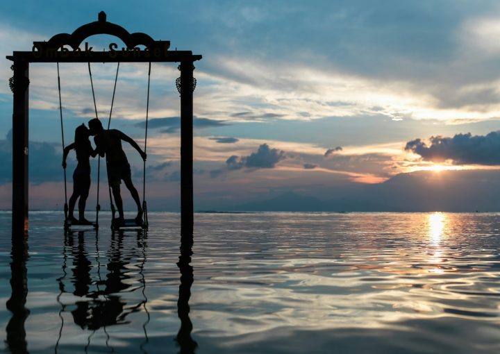 a couple standing in the sea while kissing