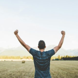 man reaching hands up high taken at daytime