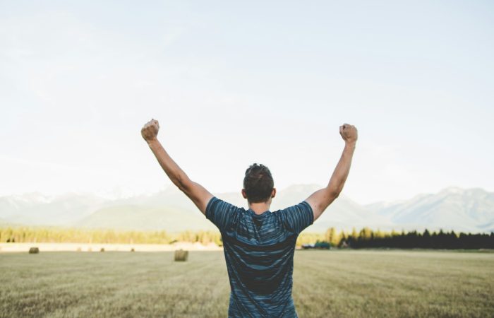 man reaching hands up high taken at daytime