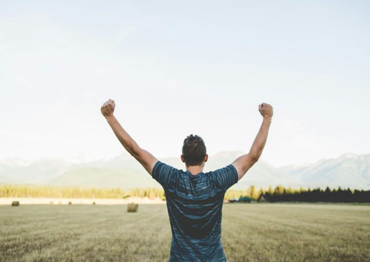 man reaching hands up high taken at daytime