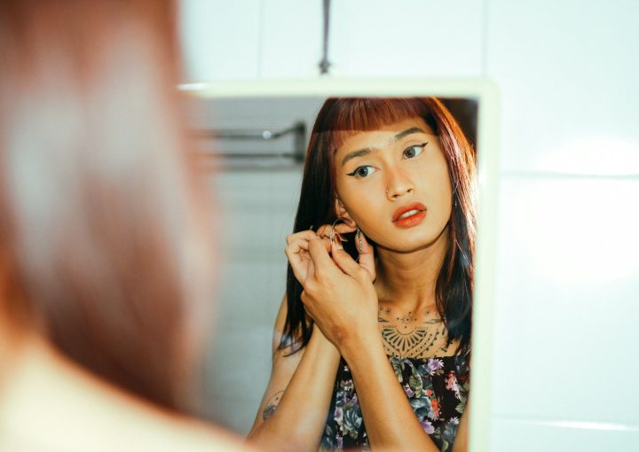 a woman looking at herself in the mirror
