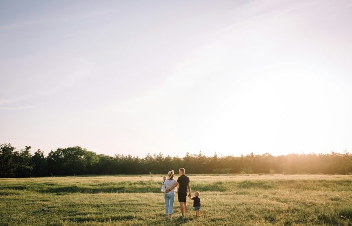 man and woman walking on green grass field during daytime