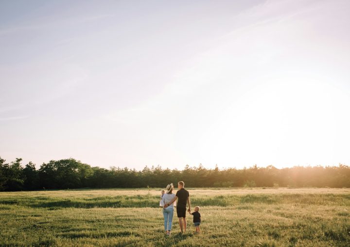 man and woman walking on green grass field during daytime